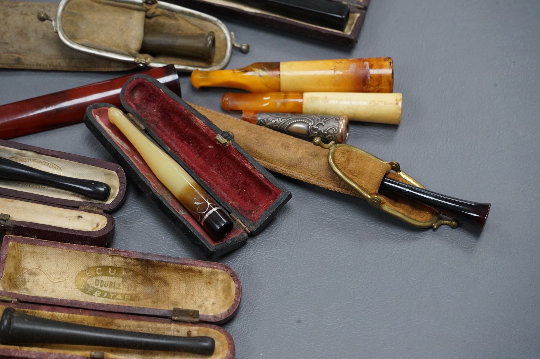 Twelve mixed cigarette and cheroot holders, some Cherry Amber, some with original cases